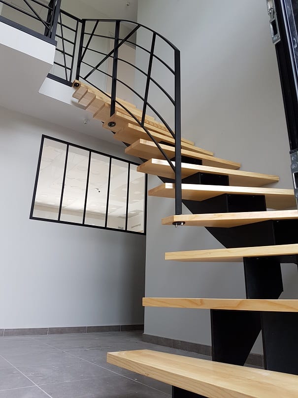 escalier en bois au premier plan et fenêtre métallique au second plan : ouvrages de métallerie et de serrurerie